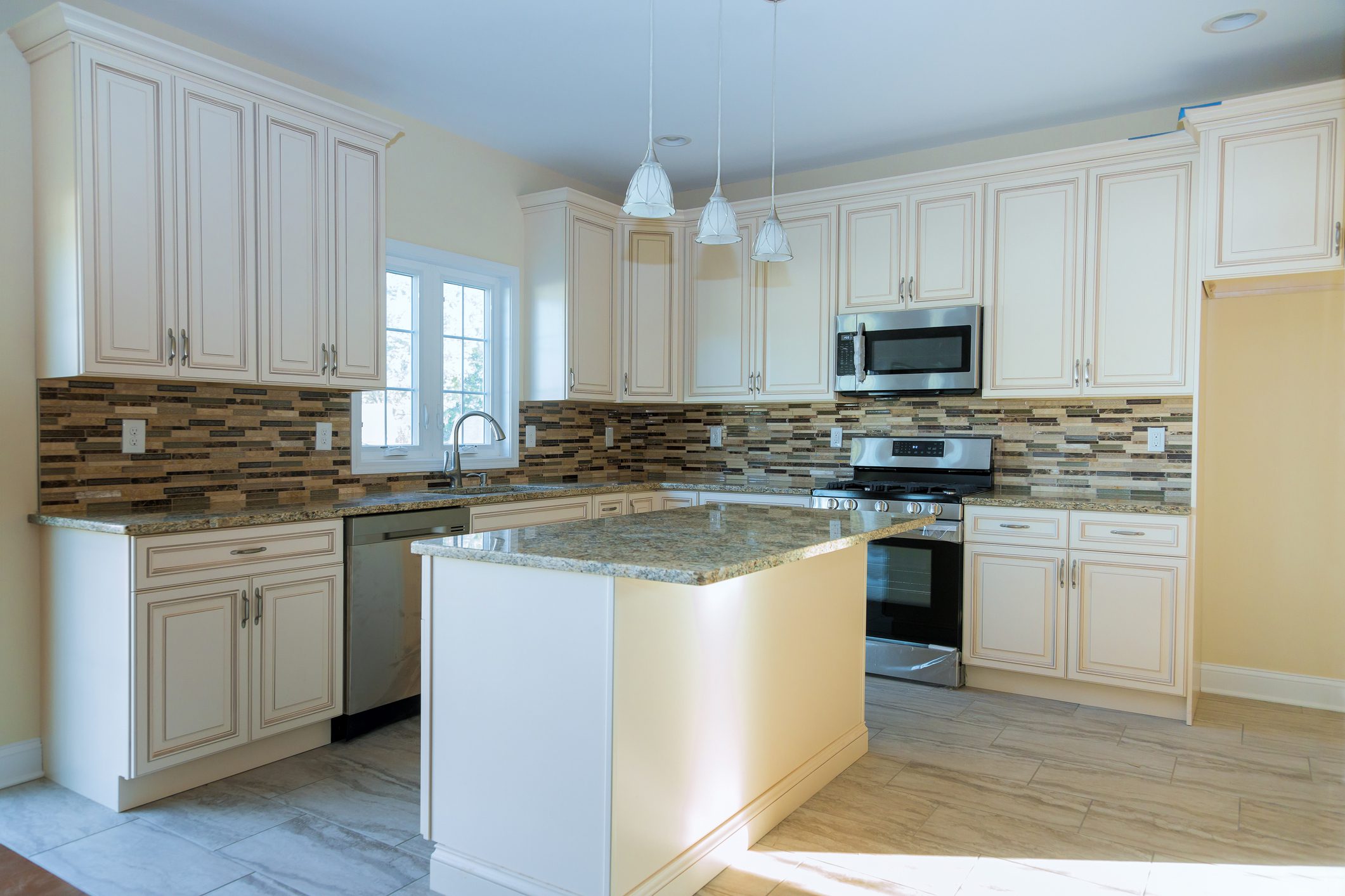 Modern kitchen with island and white cabinets.